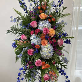Tall standing floral spray with pink, orange, blue, and lavender blooms