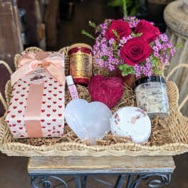 Gift basket with roses, chocolates, candles, and heart-shaped items