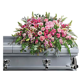 Pink floral casket spray on a silver casket