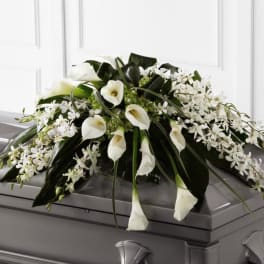 White calla lily and orchid casket spray arranged on a gray casket