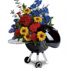 Colorful flower arrangement in a black kettle-style grill