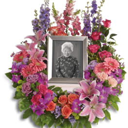 Floral photo frame wreath with pink, purple, and coral flowers around a portrait