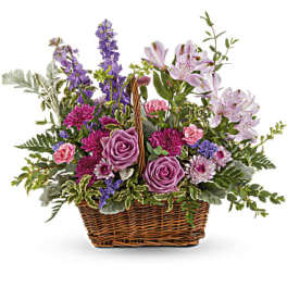 Mixed purple and pink flowers in a wicker basket