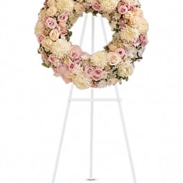 Pastel floral wreath on a white stand