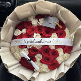 Bouquet of red and white roses wrapped in cream paper with a graduation ribbon