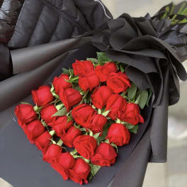 Bouquet of red roses wrapped in dramatic black paper