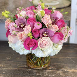 Pink and white rose bouquet with orchids in a glass vase