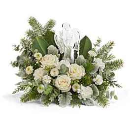 White roses and greenery arranged around a clear cross ornament