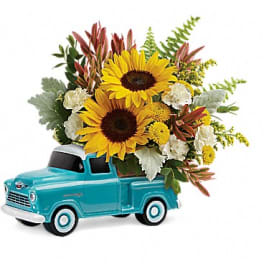Sunflowers arranged in a turquoise toy truck planter