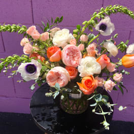 Bouquet of peach, white, and orange flowers in a glass vase