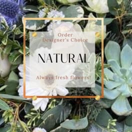 White daisies and mixed greenery with a text overlay reading "Natural."