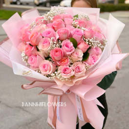Large bouquet of pink roses wrapped in pale pink paper