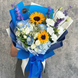 Bouquet of blue and white flowers with sunflowers wrapped in blue paper
