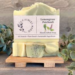 Two bars of lemongrass patchouli soap stacked on a small wooden stand