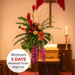 Tall tropical standing spray with red and purple flowers on an easel in a church