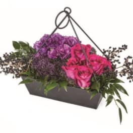 Pink and purple roses in a black handled basket