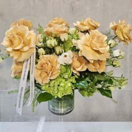 Peach roses and green hydrangeas in a glass vase