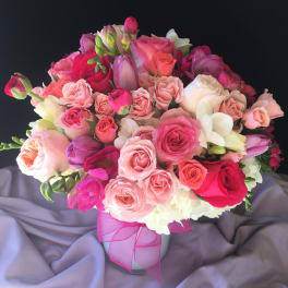 Pink and white rose bouquet in a vase with a pink ribbon