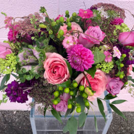 Pink and purple mixed bouquet with roses in a clear vase