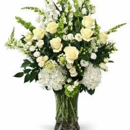 White and pale yellow floral arrangement in a glass vase