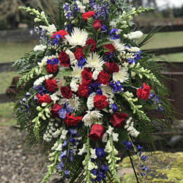 Large standing floral spray with red, white, and blue flowers