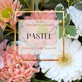 Pastel flowers with daisies and carnations behind a designer's choice label