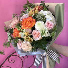 Mixed bouquet of roses, chrysanthemums, and alstroemeria wrapped in paper