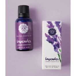 Lavender essential oil bottle with matching illustrated box on a light purple background