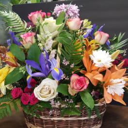 Mixed flower basket with roses, irises, lilies, and daisies