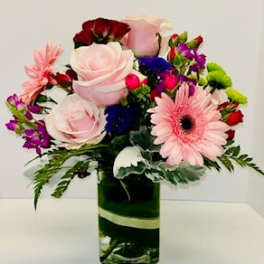 Mixed bouquet with pink roses and gerbera daisies in a glass vase