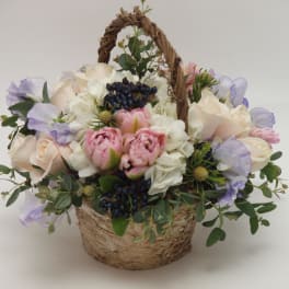 Basket arrangement of pink and white flowers with lavender accents