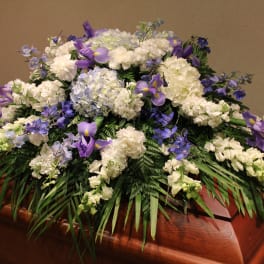 White and purple funeral spray on a casket