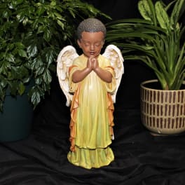 Angel figurine with potted plants on a black backdrop