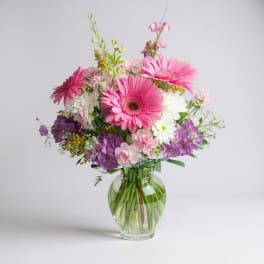 Pink and purple mixed bouquet in a clear glass vase
