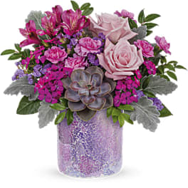 Pink roses and mixed blooms in a purple mosaic vase