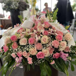 Large pink and cream rose arrangement with ribbons and lilies