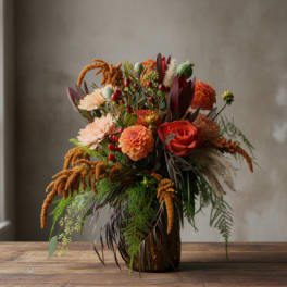 Autumn bouquet with orange and peach flowers in a glass vase