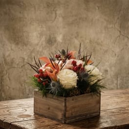 White roses and orange calla lilies in a wooden box