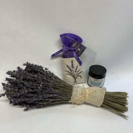 Bundle of dried lavender with a small candle jar and sachet