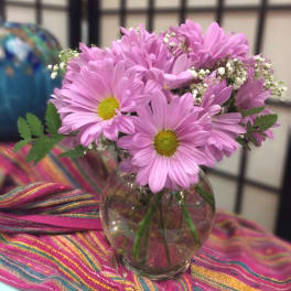Pink daisy bouquet in a clear glass vase