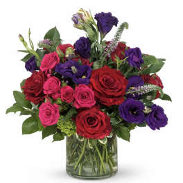 Bouquet of red, pink, and purple roses in a glass vase