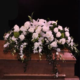 White floral casket spray with roses and lilies