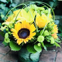 Yellow sunflower and rose arrangement in a green vase
