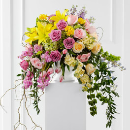 Large bouquet of pink and yellow flowers in a white vase