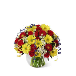 Bouquet of yellow daisies and red roses in a clear glass vase