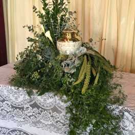 Large greenery arrangement with white calla lilies and a gold urn centerpiece