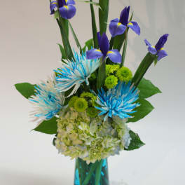 Blue iris and chrysanthemum arrangement in a glass vase
