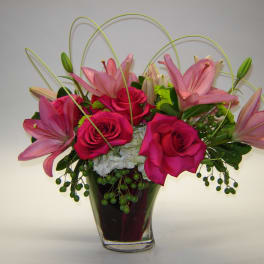 Pink roses and lilies in a clear glass vase