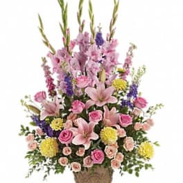 Pink lilies and roses arranged in a woven basket