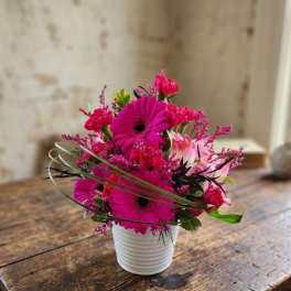 Bright pink mixed bouquet in a white ribbed pot